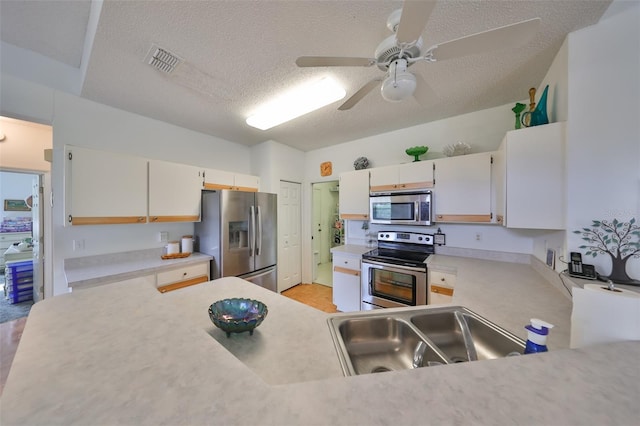 kitchen with white cabinetry, sink, a textured ceiling, and appliances with stainless steel finishes