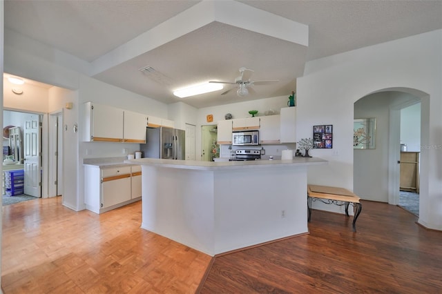 kitchen with white cabinets, stainless steel appliances, and a textured ceiling