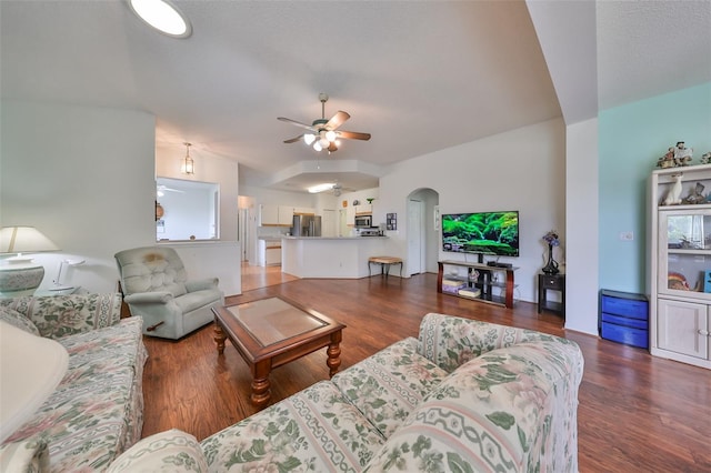 living room with ceiling fan and dark wood-type flooring