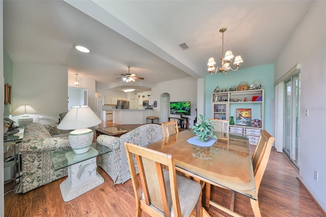 dining space featuring ceiling fan with notable chandelier and hardwood / wood-style flooring