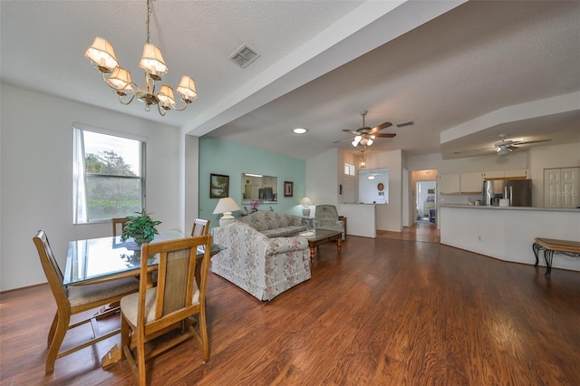 dining room with a textured ceiling, hardwood / wood-style floors, and ceiling fan with notable chandelier