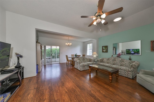 living room with a textured ceiling, dark hardwood / wood-style floors, a healthy amount of sunlight, and ceiling fan with notable chandelier