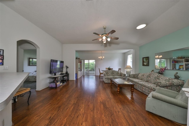 living room featuring ceiling fan with notable chandelier, a textured ceiling, and dark wood-type flooring