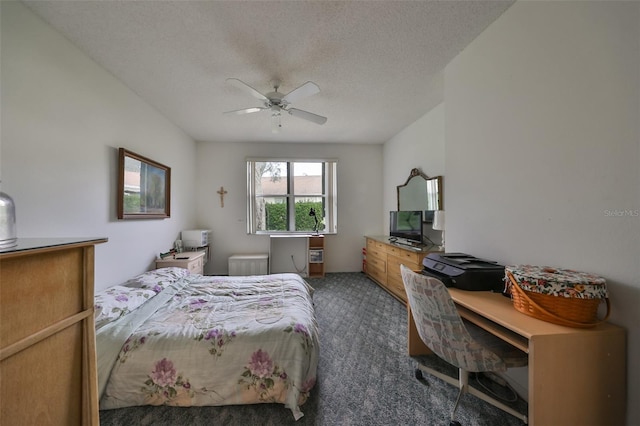 bedroom with a textured ceiling, dark carpet, and ceiling fan