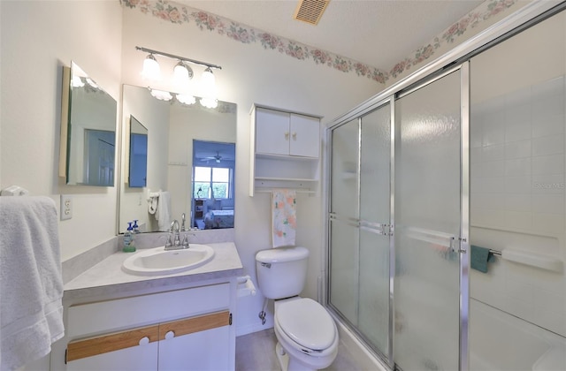 bathroom with vanity, an enclosed shower, and toilet