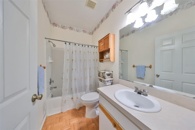 full bathroom featuring parquet floors, a textured ceiling, vanity, shower / tub combo with curtain, and toilet