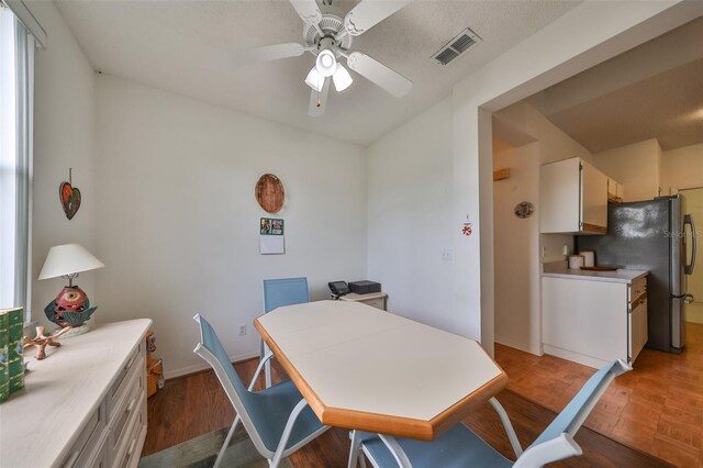 dining area with ceiling fan and dark wood-type flooring