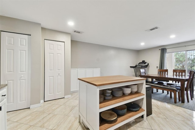 kitchen with white cabinets and butcher block countertops