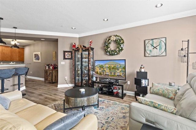 living room with wood-type flooring and ornamental molding