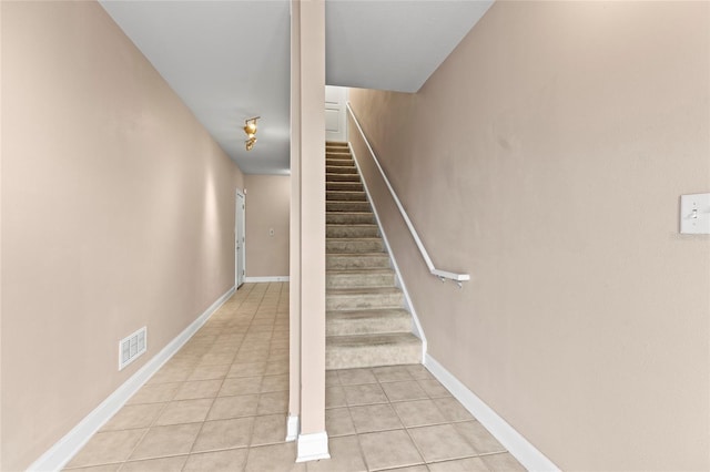 stairs featuring tile patterned flooring, visible vents, and baseboards