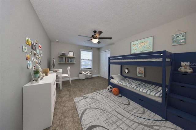 carpeted bedroom featuring ceiling fan and a textured ceiling