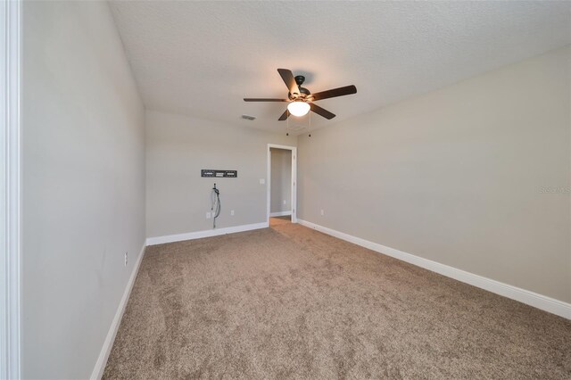 carpeted spare room featuring ceiling fan and a textured ceiling