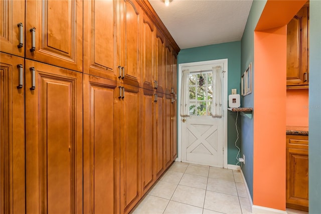 doorway featuring light tile patterned floors and a textured ceiling