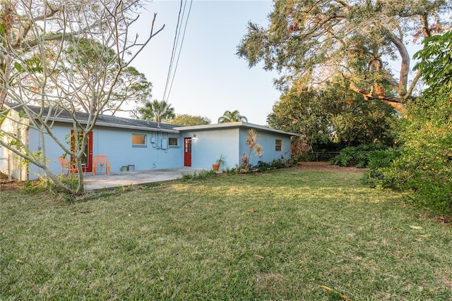 back of house featuring a patio area and a yard