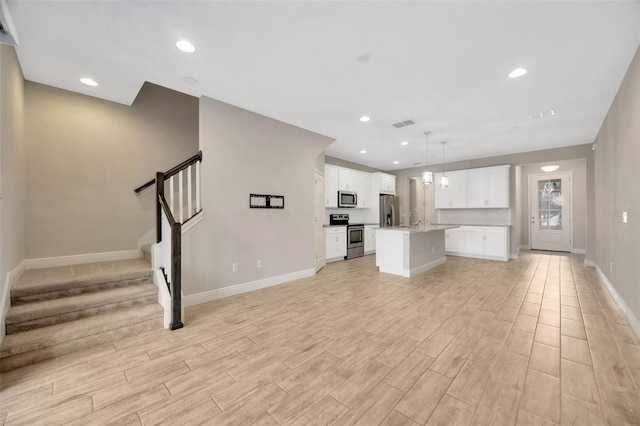 unfurnished living room with sink and light hardwood / wood-style flooring