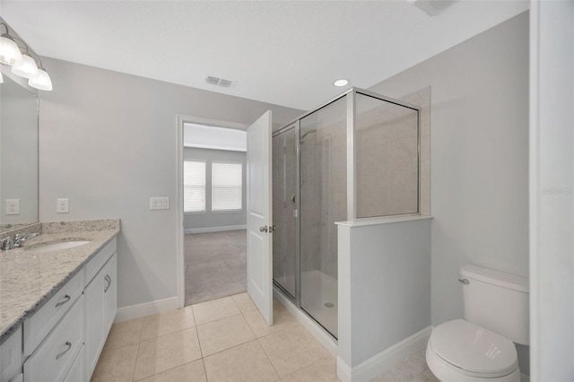 bathroom featuring tile patterned flooring, vanity, toilet, and a shower with shower door