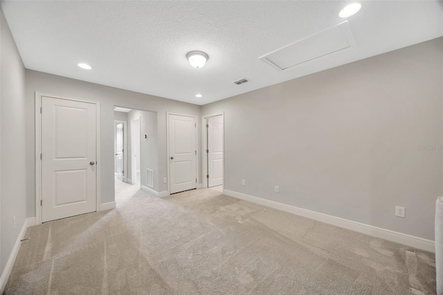 carpeted empty room featuring a textured ceiling