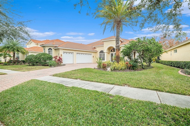 mediterranean / spanish house with a garage and a front yard