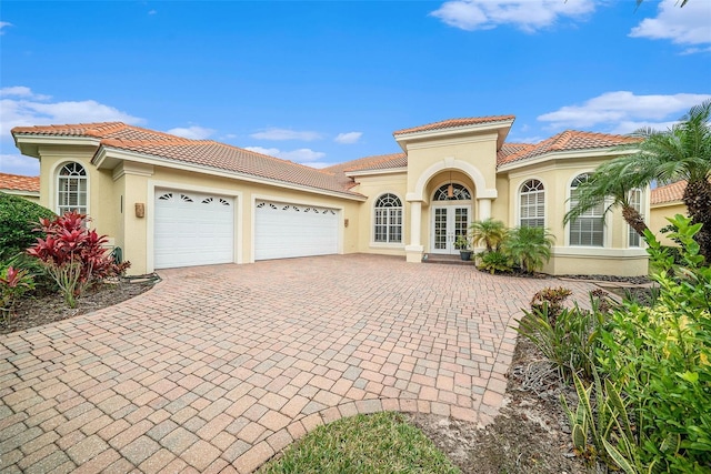 mediterranean / spanish-style house featuring a garage and french doors