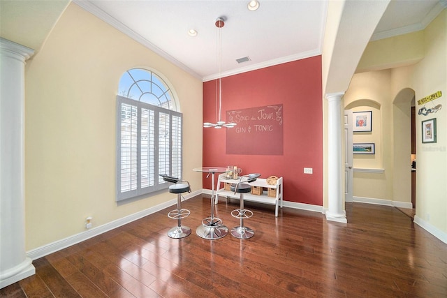 dining area with wood-type flooring, ornate columns, and ornamental molding