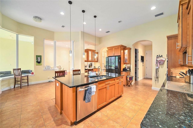 kitchen with sink, an island with sink, pendant lighting, and stainless steel dishwasher