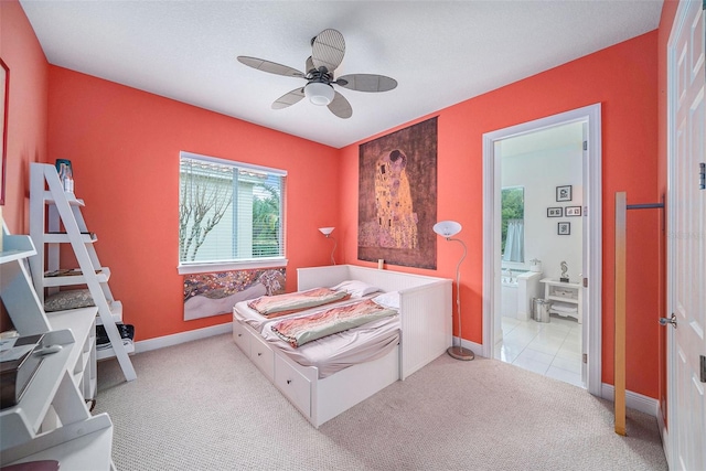 bedroom featuring ceiling fan, light carpet, and ensuite bath