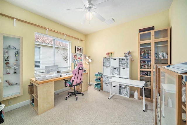 carpeted office space featuring ceiling fan