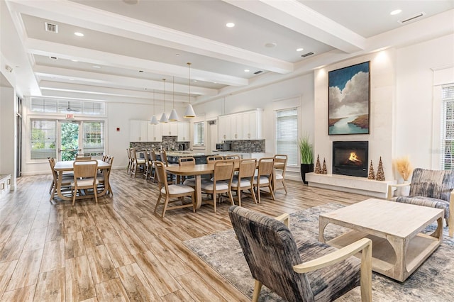 living room featuring a fireplace, light wood-type flooring, and beamed ceiling