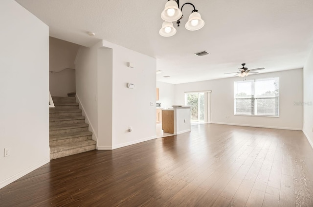 unfurnished living room featuring dark hardwood / wood-style flooring and ceiling fan with notable chandelier