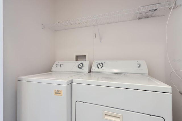 clothes washing area with washing machine and clothes dryer