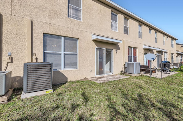 back of property featuring central AC, a patio area, and a yard