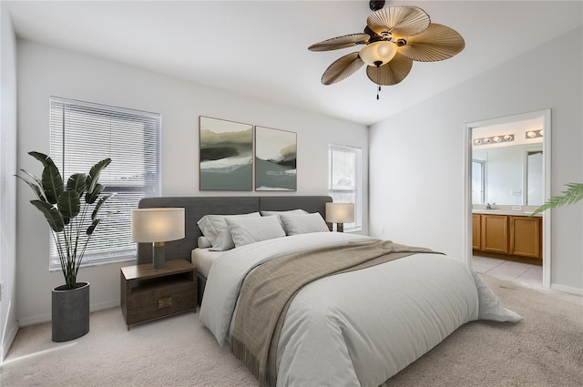 bedroom featuring ensuite bath, ceiling fan, multiple windows, and vaulted ceiling