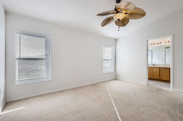 unfurnished bedroom with connected bathroom, ceiling fan, light colored carpet, and vaulted ceiling