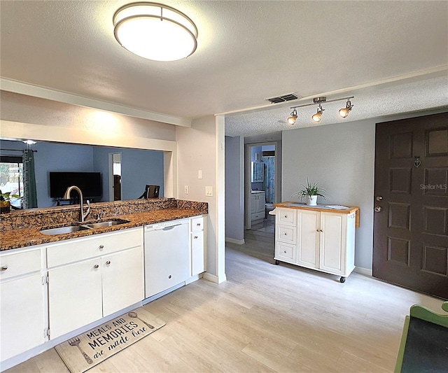 kitchen with dark stone countertops, white dishwasher, sink, and white cabinets