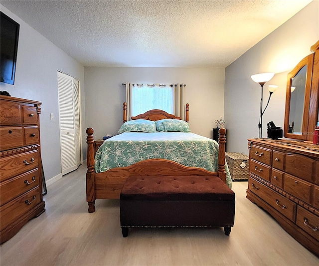 bedroom with light hardwood / wood-style floors and a textured ceiling