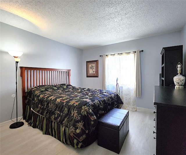 bedroom featuring wood-type flooring and a textured ceiling