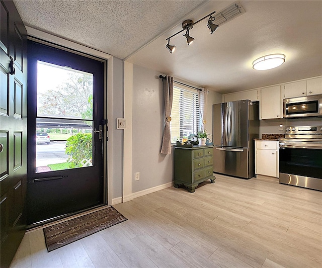 foyer featuring light hardwood / wood-style flooring and a textured ceiling