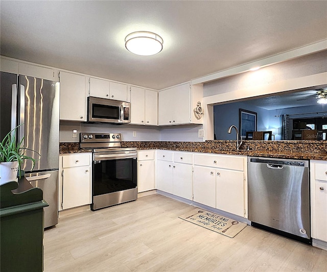 kitchen featuring white cabinetry, appliances with stainless steel finishes, sink, and light hardwood / wood-style flooring