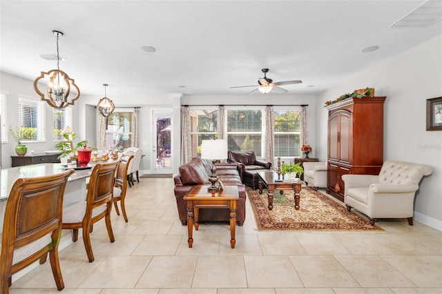 living room featuring light tile patterned floors and ceiling fan with notable chandelier