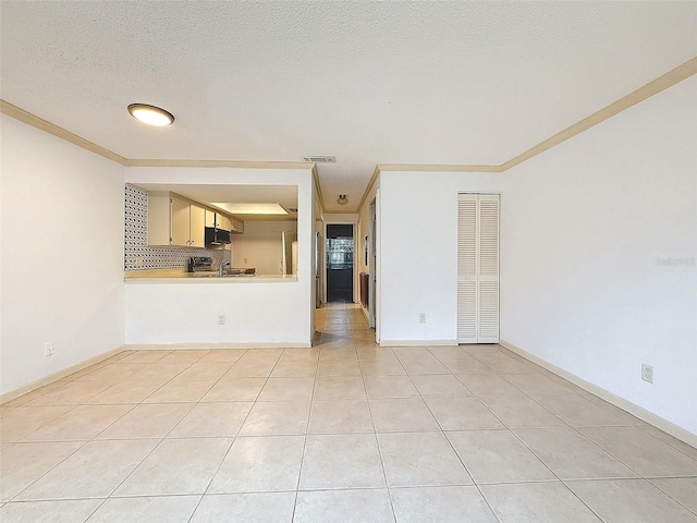 unfurnished living room with a textured ceiling, light tile patterned floors, and ornamental molding