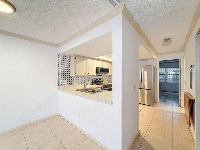 kitchen with light tile patterned floors, appliances with stainless steel finishes, sink, and ornamental molding