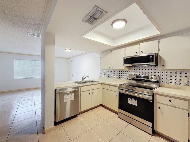 kitchen with light tile patterned floors, appliances with stainless steel finishes, sink, and a textured ceiling