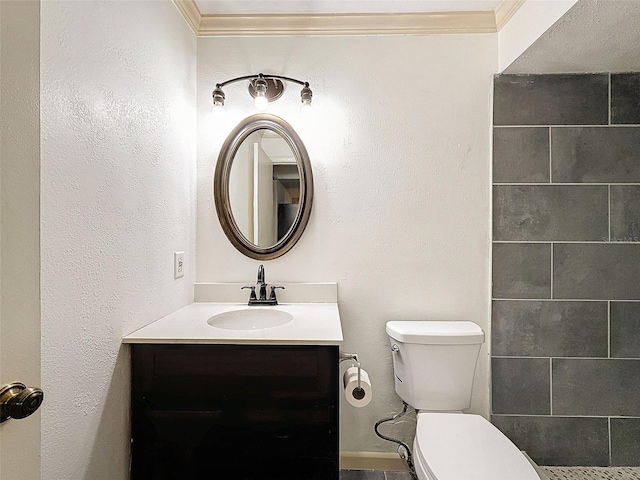 bathroom with toilet, vanity, and crown molding