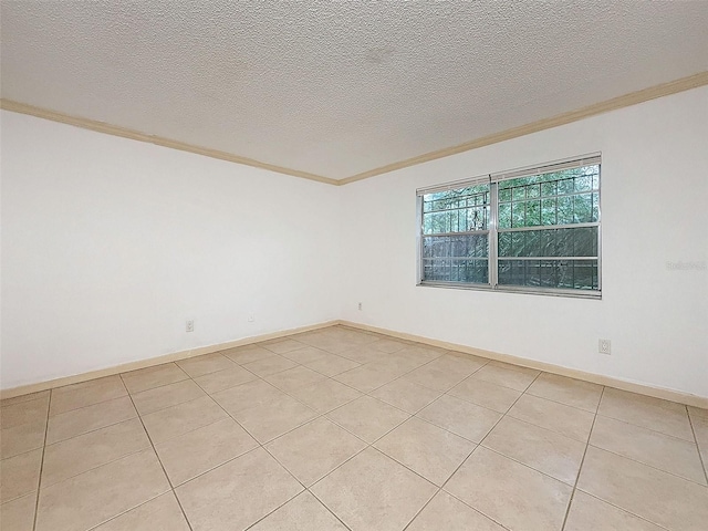 tiled spare room with ornamental molding and a textured ceiling