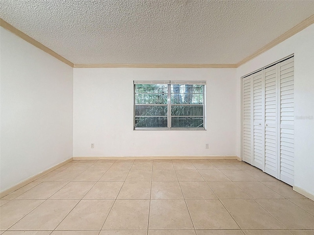 unfurnished bedroom featuring light tile patterned floors, ornamental molding, and a textured ceiling