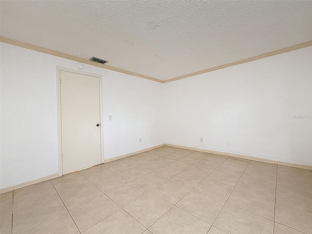 unfurnished room featuring a textured ceiling, light tile patterned floors, and ornamental molding