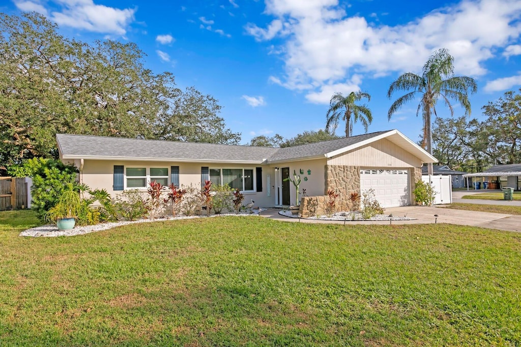 single story home featuring a garage and a front yard