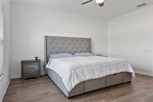 bedroom with multiple windows, hardwood / wood-style floors, and ceiling fan