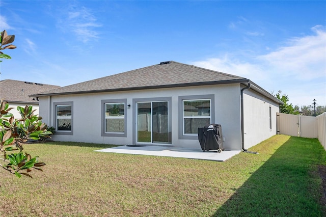 back of property with a patio area and a yard