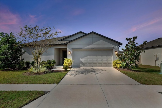 view of front of property featuring a lawn and a garage